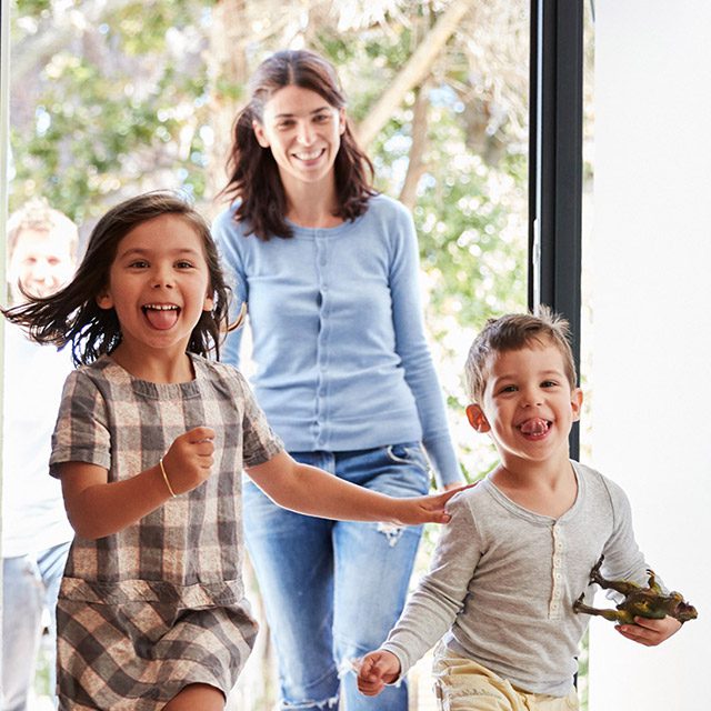 Excited Children Arriving Home With Parents